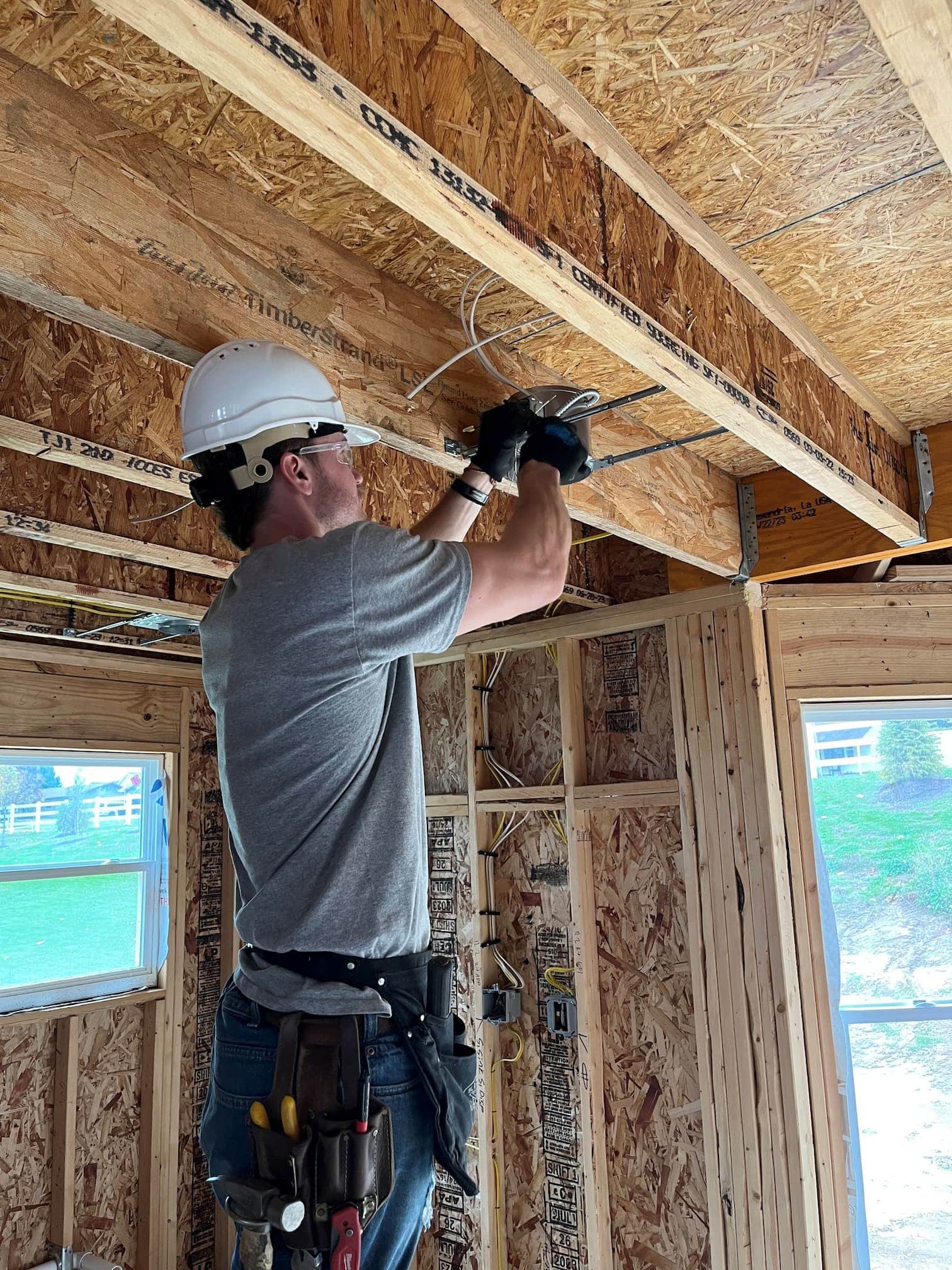 Person working on electrical wires in a ceiling